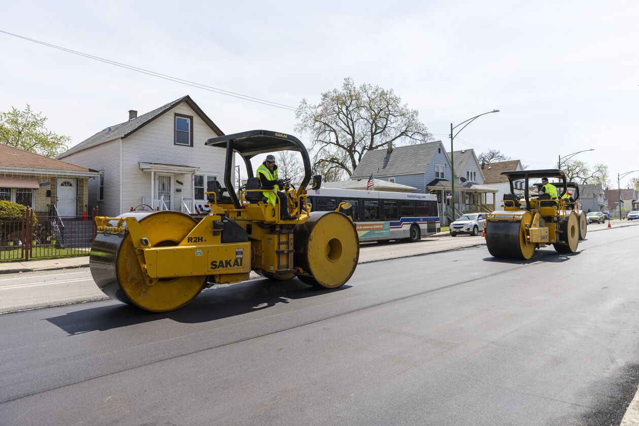 Construction workers repair and pave portions of South Damen Avenue in West Englewood Monday.